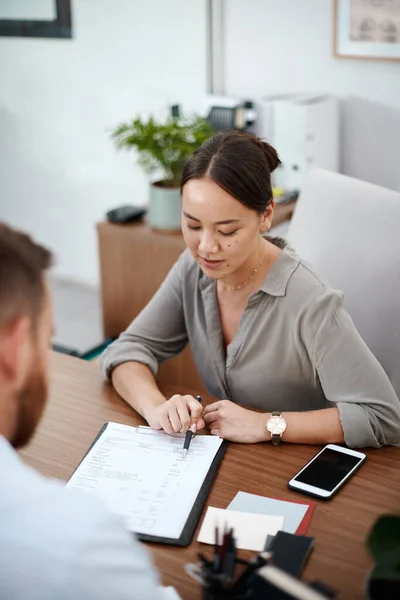 Lees dit alsjeblieft door. Opname van een zakenvrouw die een contract met een klant leest. — Stockfoto