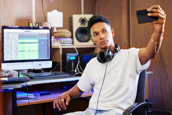 A zenei stúdiómban. Vágott felvétel egy jóképű fiatal férfi zenei producerről, aki szelfiket készít, miközben az otthoni irodájában dolgozik.. — Stock Fotó