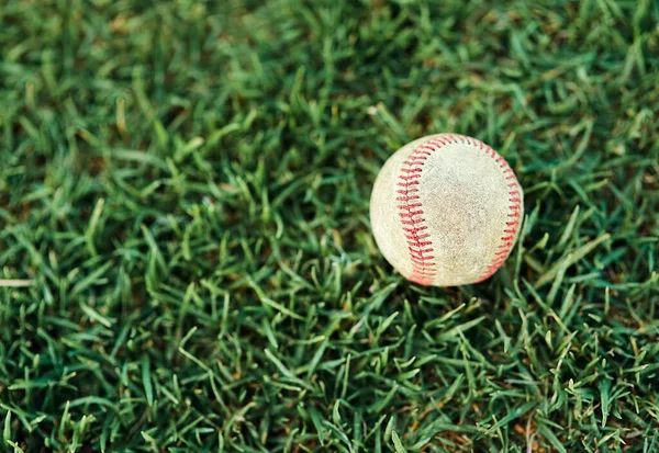 Zagrajmy w baseball. Strzał baseballu leżącego na boisku. — Zdjęcie stockowe