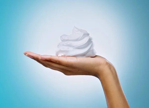 Ive avoided shaving for far too long now. Cropped shot of an unrecognisable woman holding a handful of shaving cream against a blue background in the studio. — Stock Photo, Image