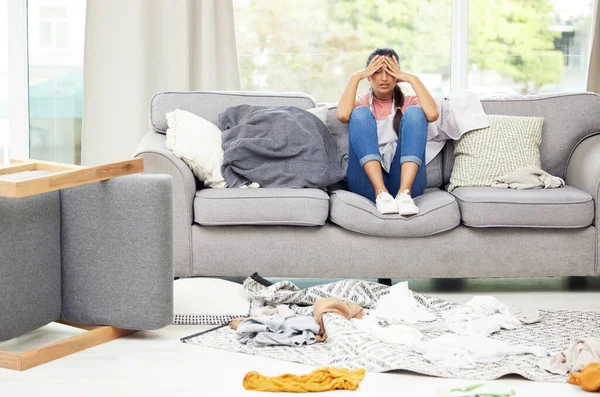 I just want to chill. Shot of a young woman feeling overwhelmed while sitting in a messy living room. — Stock Photo, Image
