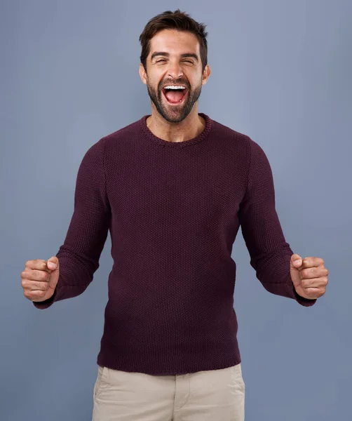 Ahora vale la pena celebrarlo. Estudio de un joven guapo animando contra un fondo gris. —  Fotos de Stock