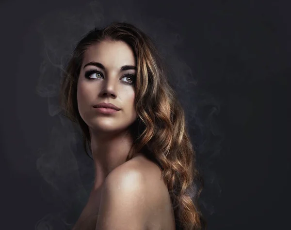 Elle est jeune et belle. Studio concept shot d'une belle jeune femme avec de la fumée sortant de son. — Photo