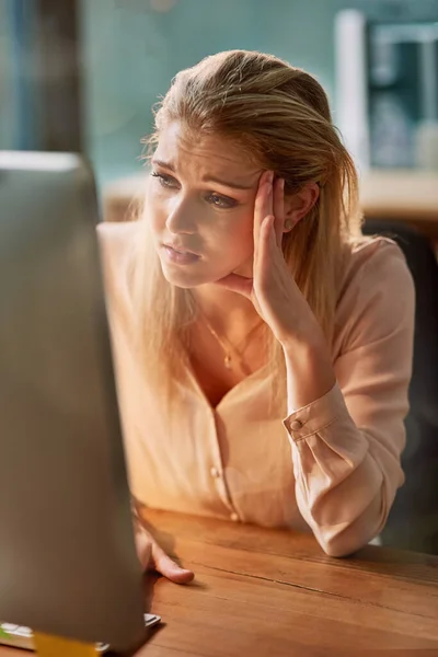 C'est une longue journée au bureau. Tournage d'une jeune femme d'affaires épuisée travaillant sur un ordinateur dans un bureau. — Photo