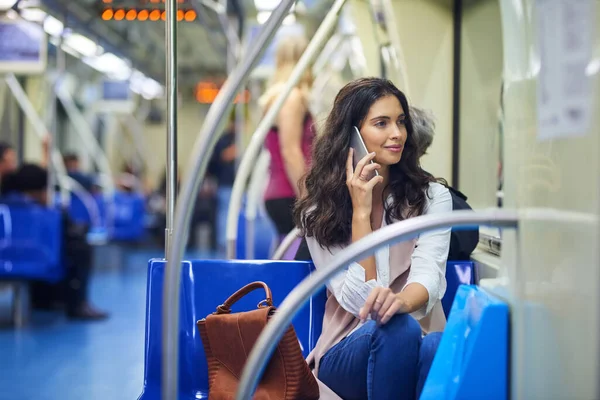 Koppla upp dig på pendlingen. Beskuren bild av en ung attraktiv kvinna på ett samtal och använda tåget för att pendla. — Stockfoto