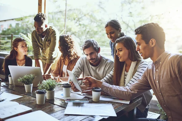 Raus aus dem Büro, um Geschäfte zu machen. Aufnahme eines Teams von Kollegen, die gemeinsam ein digitales Tablet und einen Laptop benutzen, während eines Treffens in einem Outdoor-Café. — Stockfoto