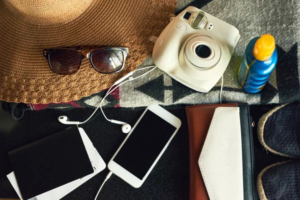 Quando o desejo de viajar atacar, faça as malas e explore. Tiro de ângulo alto de itens essenciais de viagem em uma mesa. — Fotografia de Stock