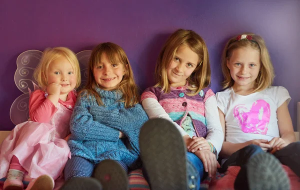 子供の頃の陽気。紫色の背景に座っている女の子のグループの肖像画. — ストック写真