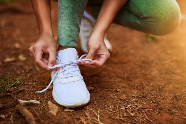 편안 한 옷을 입도록 해. 도망가기 전에 신발 끈을 묶고 있는 한 젊은 산적 한 여자의 사진. — 스톡 사진
