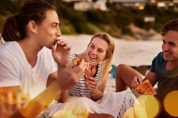 La pizza est une bonne nourriture. Tournage d'un groupe d'amis assis ensemble sur la plage. — Photo