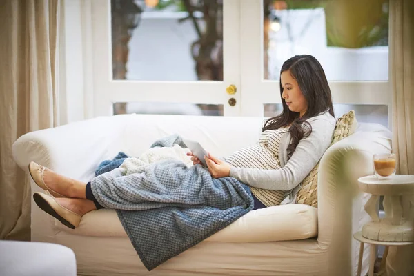 Ze besloot om te bloggen over haar grote zwangerschapsreis. Afbeelding van een zwangere vrouw met een digitale tablet thuis. — Stockfoto