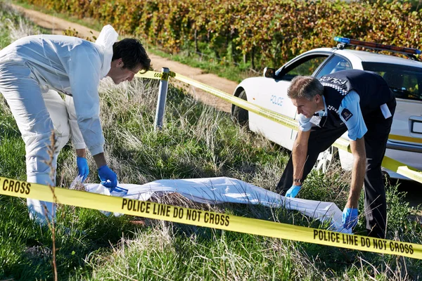 Den Körper bedecken. Aufnahme von zwei Ermittlern, die am Tatort eine Leichensäcke abholen. — Stockfoto
