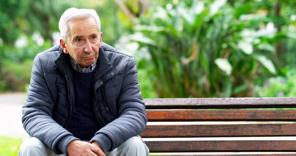 Y ahora estoy sola. Foto recortada de un anciano despreocupado sentado en un banco mientras contemplaba el exterior en un parque. — Foto de Stock