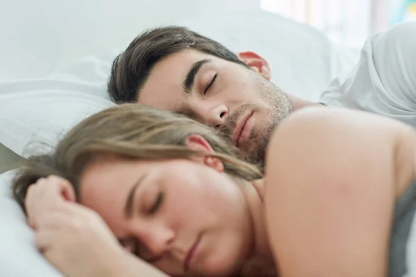 Kein Grund zur Eile heute. Aufnahme eines entspannten jungen Paares, das zu Hause zusammen im Bett schläft. — Stockfoto