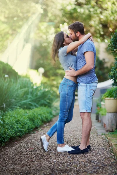 Leva med romantik. Skjuten av en ung kyss medan du njuter av en dag tillsammans utanför. — Stockfoto
