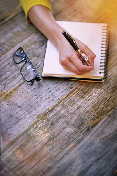 Es un lienzo en blanco para sus pensamientos. Recorte de una mujer sentada en una mesa y escribiendo en su bloc de notas. —  Fotos de Stock
