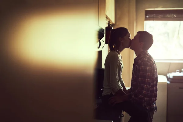 Aquele beijo que te completa. Tiro de um jovem casal afetuoso compartilhando um beijo romântico na cozinha. — Fotografia de Stock