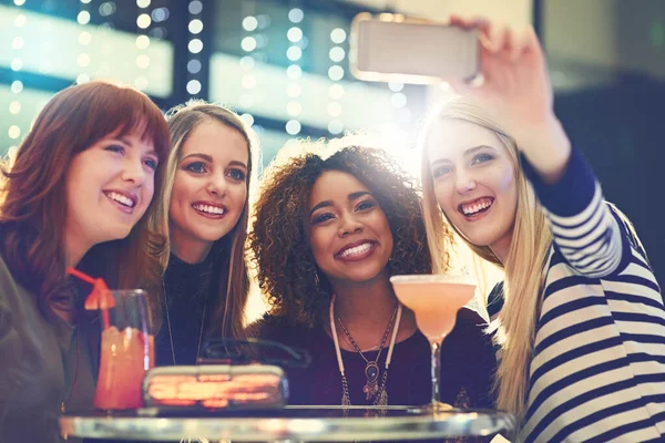 Preparem as vossas caras de selfie. Tiro de um grupo de amigos felizes tirando uma selfie enquanto desfruta de coquetéis. — Fotografia de Stock