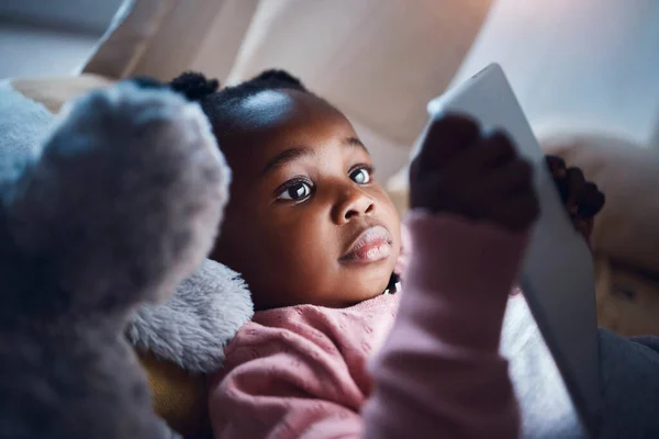 Me alegra que mamá me deje leer en la cama. Foto de una niña usando su tableta digital en su dormitorio. —  Fotos de Stock
