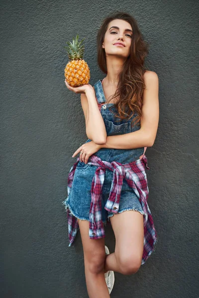 Que quer ananás. Retrato de uma jovem alegre segurando um abacaxi enquanto estava contra um fundo cinza. — Fotografia de Stock