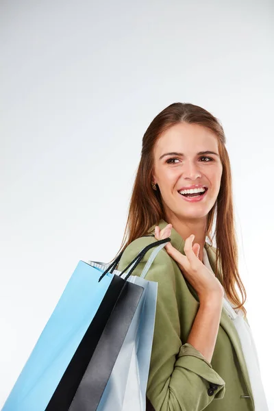 Dat was een productieve winkeltocht. Studio shot van een gelukkige jonge vrouw dragen boodschappentassen tegen een grijze achtergrond. — Stockfoto