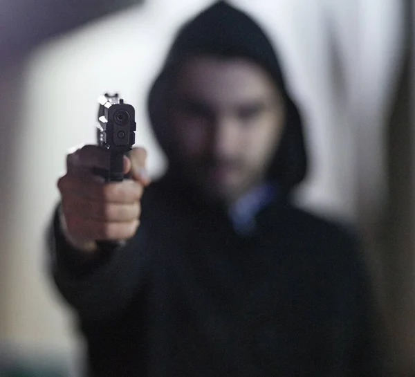 Desperate times call for desperate measures. Shot of a gun-wielding thief aiming his weapon. — Stock Photo, Image