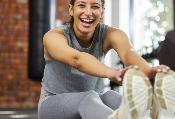 Salud y felicidad van de la mano. Retrato de una joven deportista estirando las piernas mientras hace ejercicio en un gimnasio. —  Fotos de Stock