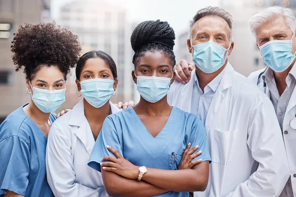 Esta pandemia não vai derrubá-los. Tiro de um grupo de médicos em pé na cidade. — Fotografia de Stock