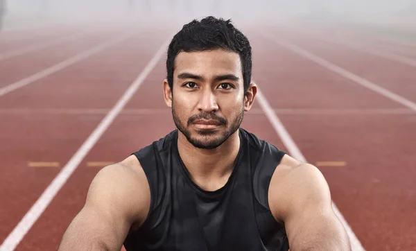 A determinação dá-me sempre essa vitória. Tiro de um jovem atleta sentado na pista antes de uma corrida. — Fotografia de Stock