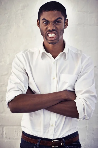 Ich hatte gerade genug. Aufnahme eines ernsten jungen Mannes, der mit verschränkten Armen steht. — Stockfoto