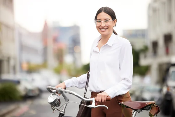 尽她的职责减少空气污染。一个年轻女子骑自行车游览城市的画像. — 图库照片