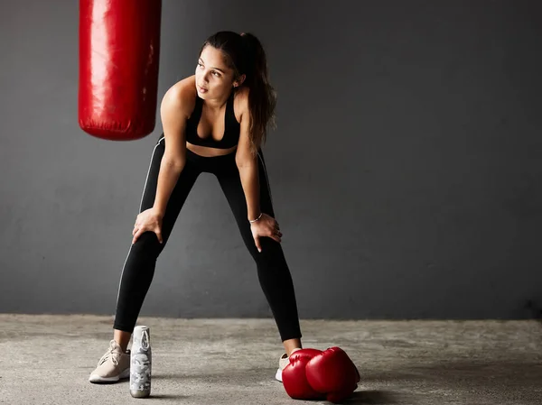 To dopiero trening. Full length shot atrakcyjnej młodej bokserki wyglądającej na zmęczoną podczas treningu na siłowni. — Zdjęcie stockowe