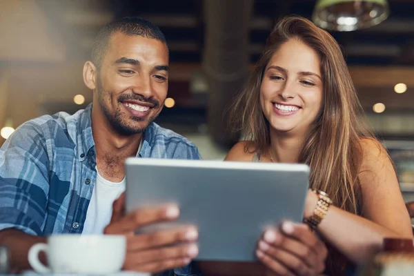 Os clientes recebem wi-fi gratuito neste café. Tiro recortado de um jovem casal usando um tablet digital enquanto estava sentado em um café. — Fotografia de Stock