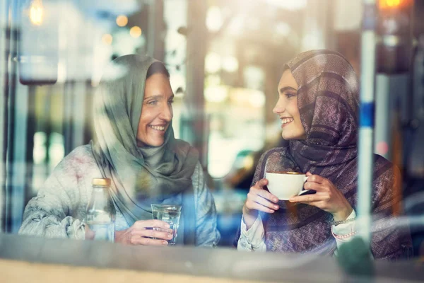 Koffie smaakt beter samen. Schot van twee vrouwen die aan het kletsen waren in een café.. — Stockfoto
