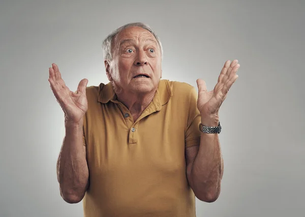 Dat zag ik niet aankomen. Studio van een oudere man in ongeloof tegen een grijze achtergrond. — Stockfoto