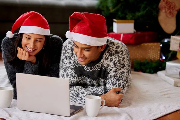 Ich werde Weihnachten in meinem Herzen ehren und versuchen, es das ganze Jahr über aufrecht zu erhalten. Aufnahme eines Paares, das sich zu Hause Filme auf einem Laptop anschaut. — Stockfoto