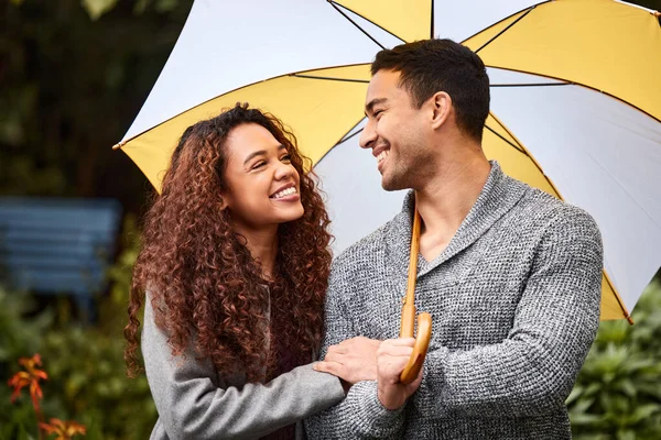Possiamo superare la tempesta insieme. Girato di una giovane coppia sotto la pioggia con un ombrello. — Foto Stock