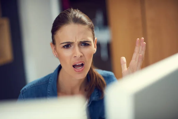 Varför är internet så långsamt? Skjuten av en ung affärskvinna som använder en dator och ser arg ut på ett modernt kontor. — Stockfoto