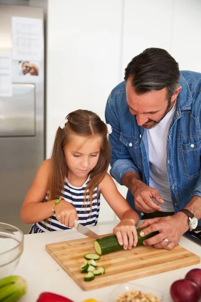 Como um chef profissional. Tiro de uma menina adorável cozinhar com seu pai em casa. — Fotografia de Stock