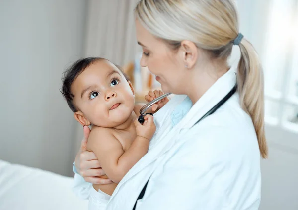 귀여운 작은 사람들을 돌보는 것은 매우 보람있는 일입니다. 어느 소아과 의사 가 병원에서 아기를 진찰하고 있는 장면이 찍힌 사진. — 스톡 사진