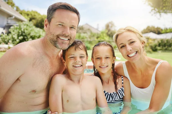 Nadar é uma habilidade importante na vida. Tiro de um casal e seus dois filhos passando tempo na piscina. — Fotografia de Stock