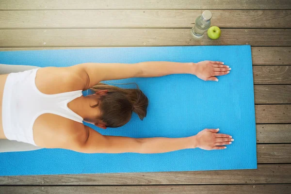 Sie durchläuft ihre Yoga-Routine. Weitwinkelaufnahme einer jungen Frau beim Training zu Hause. — Stockfoto