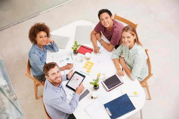 Temos este projecto sob controlo. Retrato de alto ângulo de um grupo de empresários trabalhando juntos em torno de uma mesa em um escritório. — Fotografia de Stock
