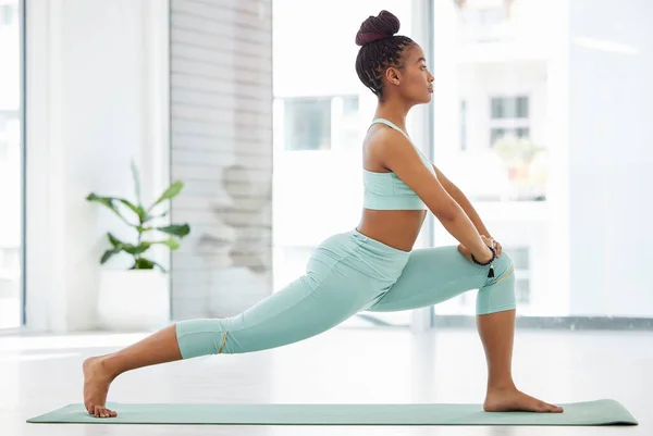 Yoga tamamen denge ile ilgilidir. Stüdyoda yoga yapan ve yüksek hamleler yapan çekici bir genç kadının tam boy çekimi.. — Stok fotoğraf