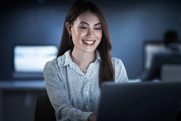 Widać wyraźnie jej poświęcenie. Zdjęcia młodej bizneswoman pracującej na laptopie w biurze w nocy. — Zdjęcie stockowe