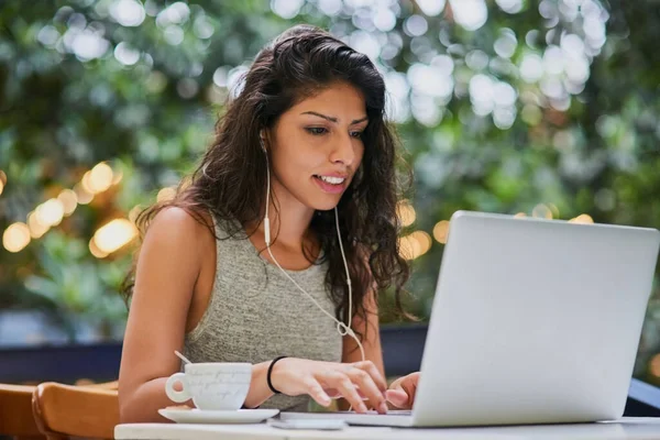 Navigando fuori l'aria fresca. Girato di una giovane donna attraente che utilizza un computer portatile in un caffè. — Foto Stock