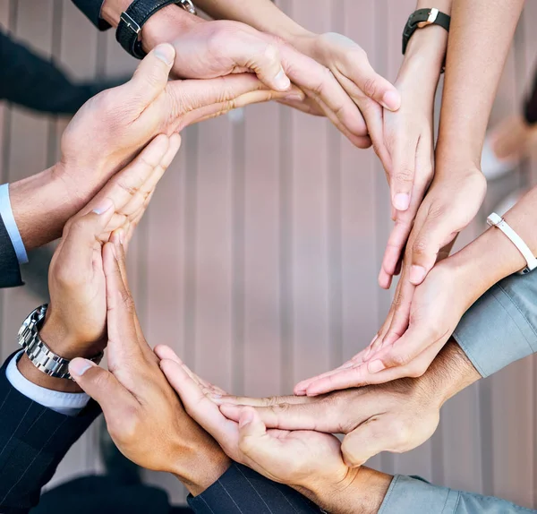 El negocio sólo funciona si lo hacemos. Alto ángulo de tiro de un grupo de empresarios irreconocibles formando un círculo con sus manos en el trabajo. — Foto de Stock