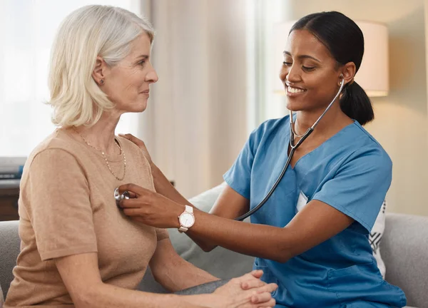 De beste dokters doen huisbezoeken. Schot van een arts die een oudere vrouw onderzoekt met een stethoscoop thuis. — Stockfoto