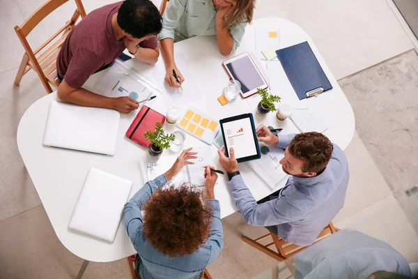 Eccelgono negli affari. Foto ad alto angolo di un gruppo di uomini d'affari che lavorano insieme intorno a un tavolo in un ufficio. — Foto Stock