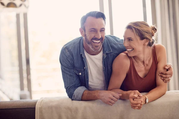 Tutto ciò di cui hai bisogno è amore e risate. Girato di una coppia felice che si rilassa sul divano di casa. — Foto Stock